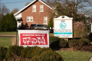 Donation drop-off sign for Toys for Tots in front of BZ Orthodontics office building, promoting community engagement and holiday initiatives.