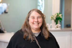Smiling woman in a dental office, representing BZ Orthodontics and patient care in Lansdale, PA, highlighting the welcoming environment for orthodontic consultations.
