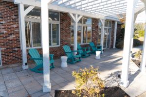 Outdoor seating area at BZ Orthodontics Lansdale office with turquoise chairs and a pergola, inviting space for consultations about braces and Invisalign in Lansdale, PA.