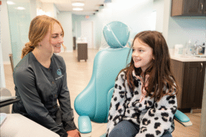 Young patient smiling with orthodontic assistant in modern clinic, highlighting BZ Orthodontics' friendly environment and personalized care for braces and Invisalign in Lansdale, PA.