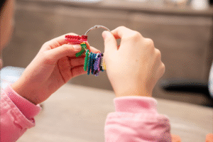 Child's hands holding colorful orthodontic braces components, representing BZ Orthodontics and the experience of getting braces in Lansdale, PA.