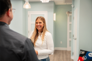 Smiling woman interacting with a staff member in a modern orthodontic office, representing BZ Orthodontics and patient consultations for Invisalign and braces in Lansdale, PA.