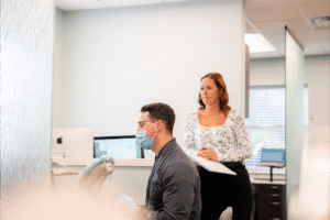 Dental professional assisting patient in orthodontic office, BZ Orthodontics, focused on Invisalign treatment and braces in Lansdale, PA.