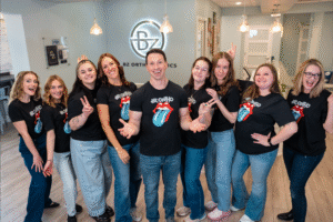 BZ Orthodontics team posing together, featuring Dr. Zebriek and staff in branded t-shirts, showcasing a friendly atmosphere in the orthodontic practice, promoting Invisalign and braces services in Lansdale, PA.
