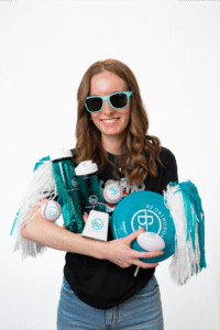 Fun team member of BZ Orthodontics holding promotional items, showcasing a friendly atmosphere for potential patients in Lansdale, PA.