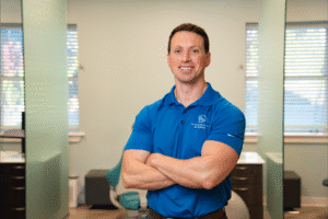 Dr. Brian Zebrick in blue polo shirt, smiling and standing confidently in BZ Orthodontics office, showcasing expertise in orthodontics, including Invisalign and braces in Lansdale, PA.