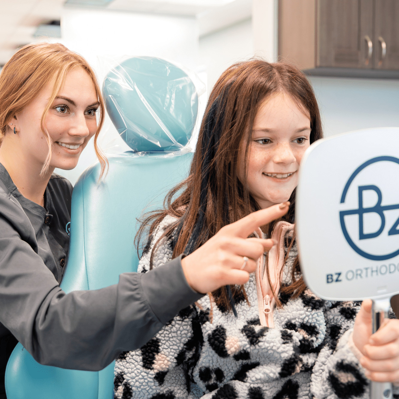 Orthodontist interacting with young patient in BZ Orthodontics office, showcasing clear braces options and encouraging confidence in treatment.