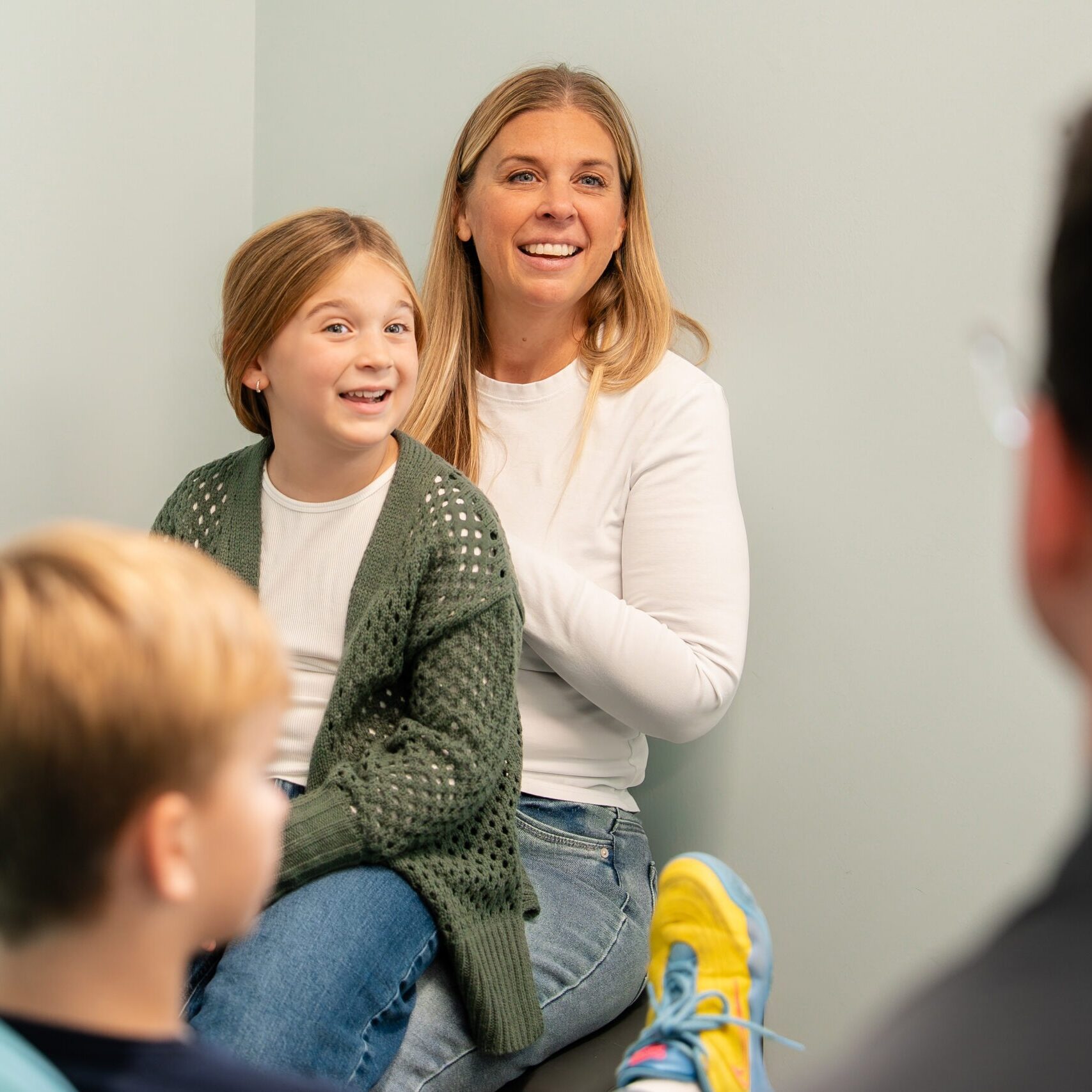 Smiling mother and daughter with a young boy during a visit at BZ Orthodontics